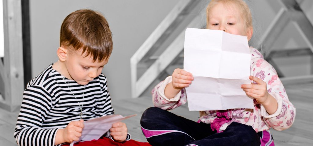 Children holding letters from Santa, part of North Pole subscription